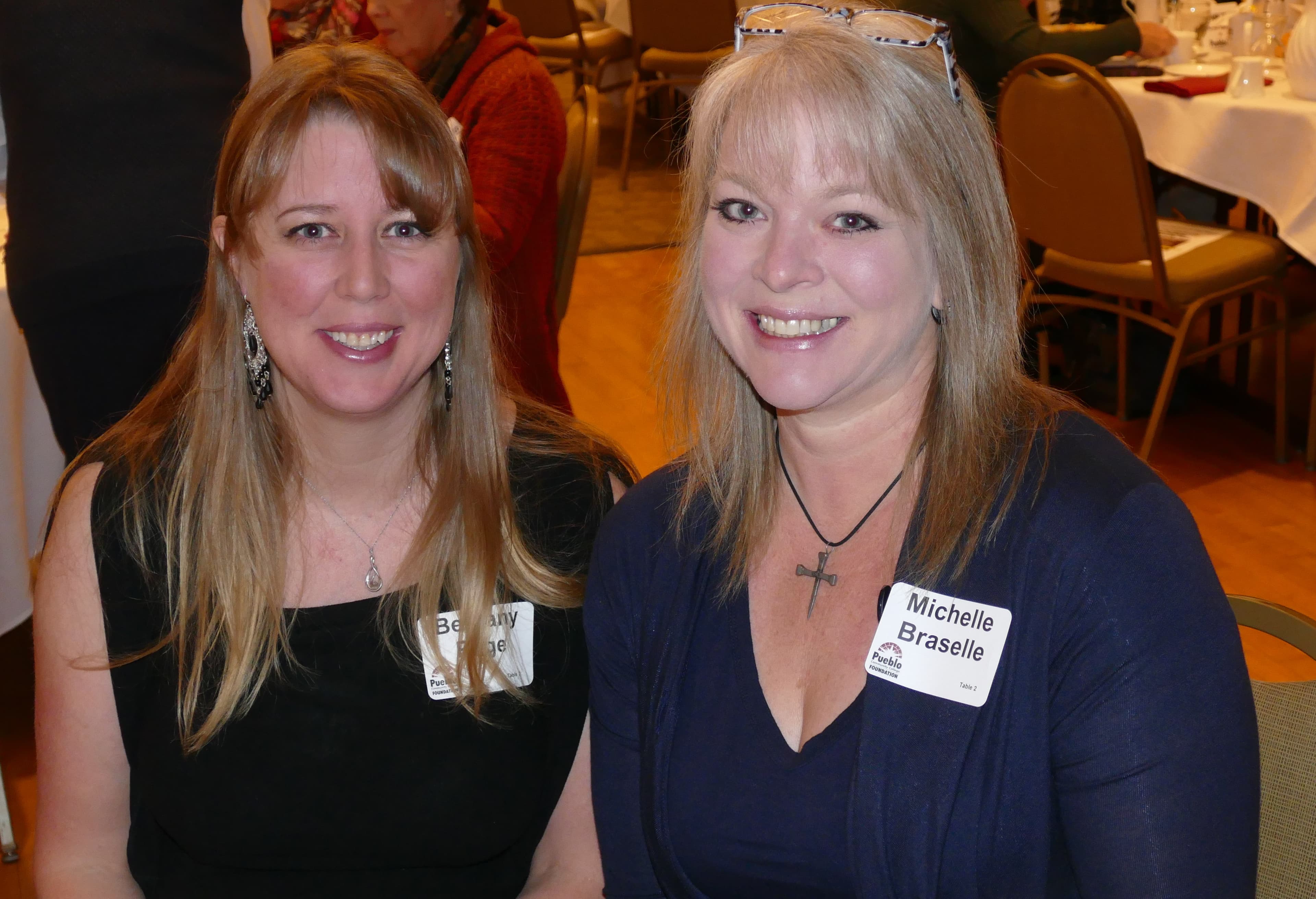 Bethany and Michelle, smiling, seated together at a PCC Foundation event