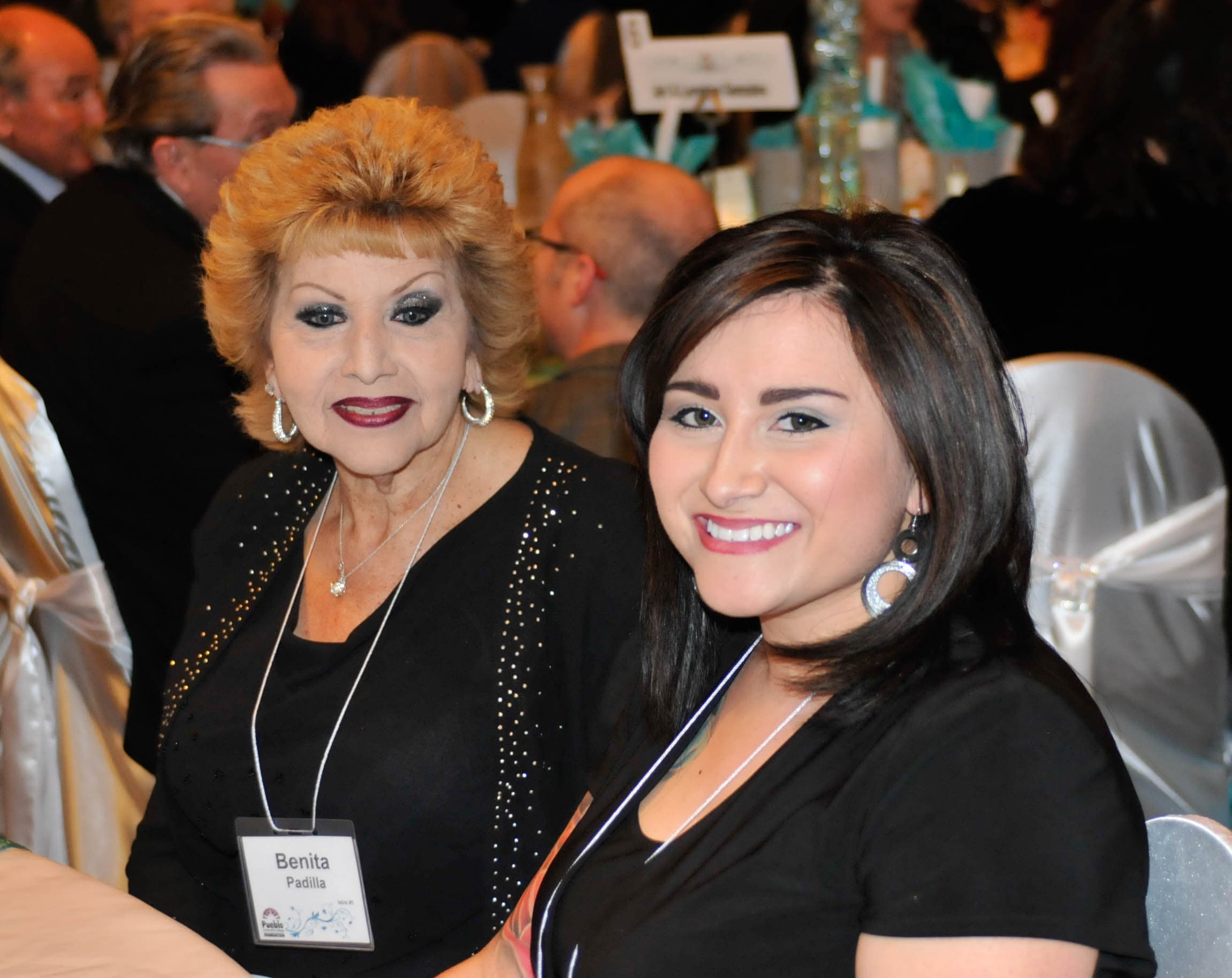 A young woman smiles at a PCC Foundation event table
